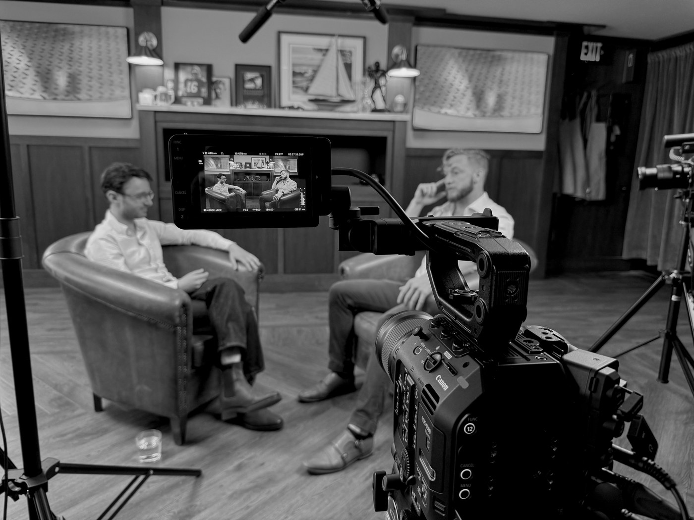 Camera filming two executives during a studio interview